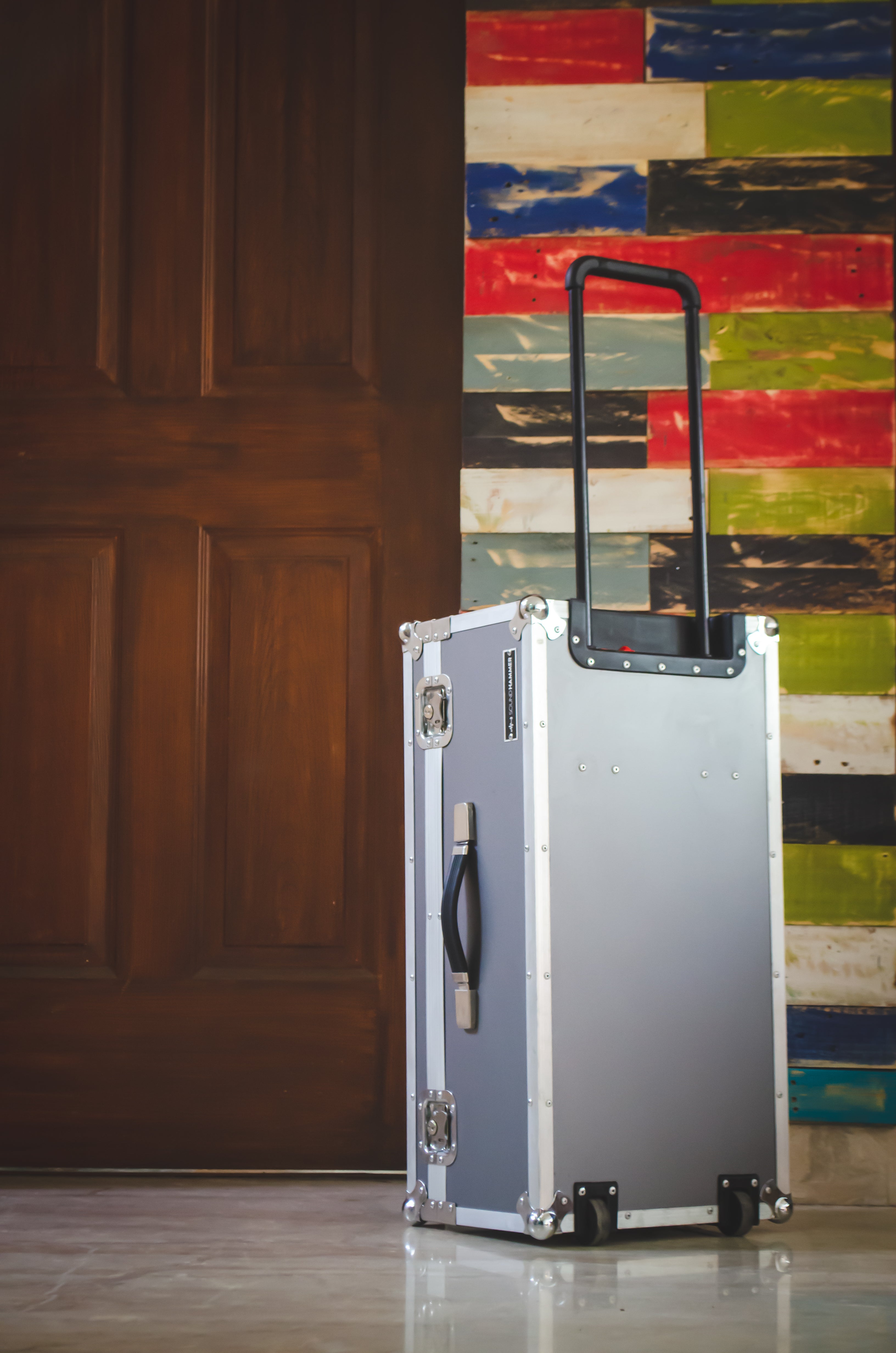 side view of a grey custom guitar pedalboard flight case with pulling handle stretched out