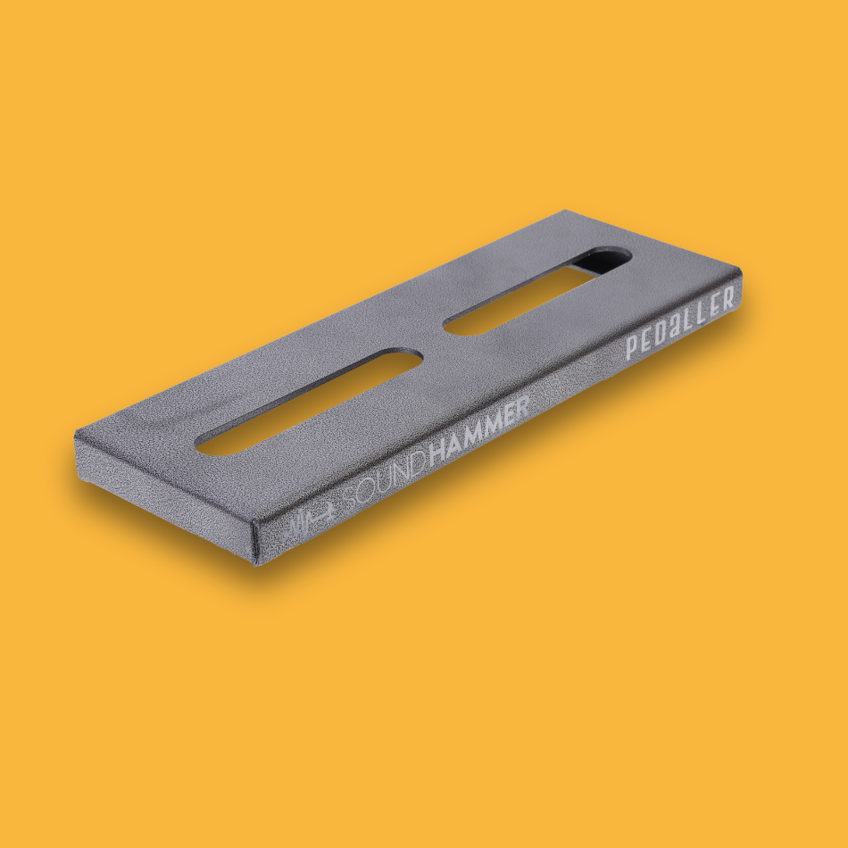 A top-angled view of a grey guitar effects pedalboard made of single sheet of aluminium with two long holes for cable management with Soundhammer logo.