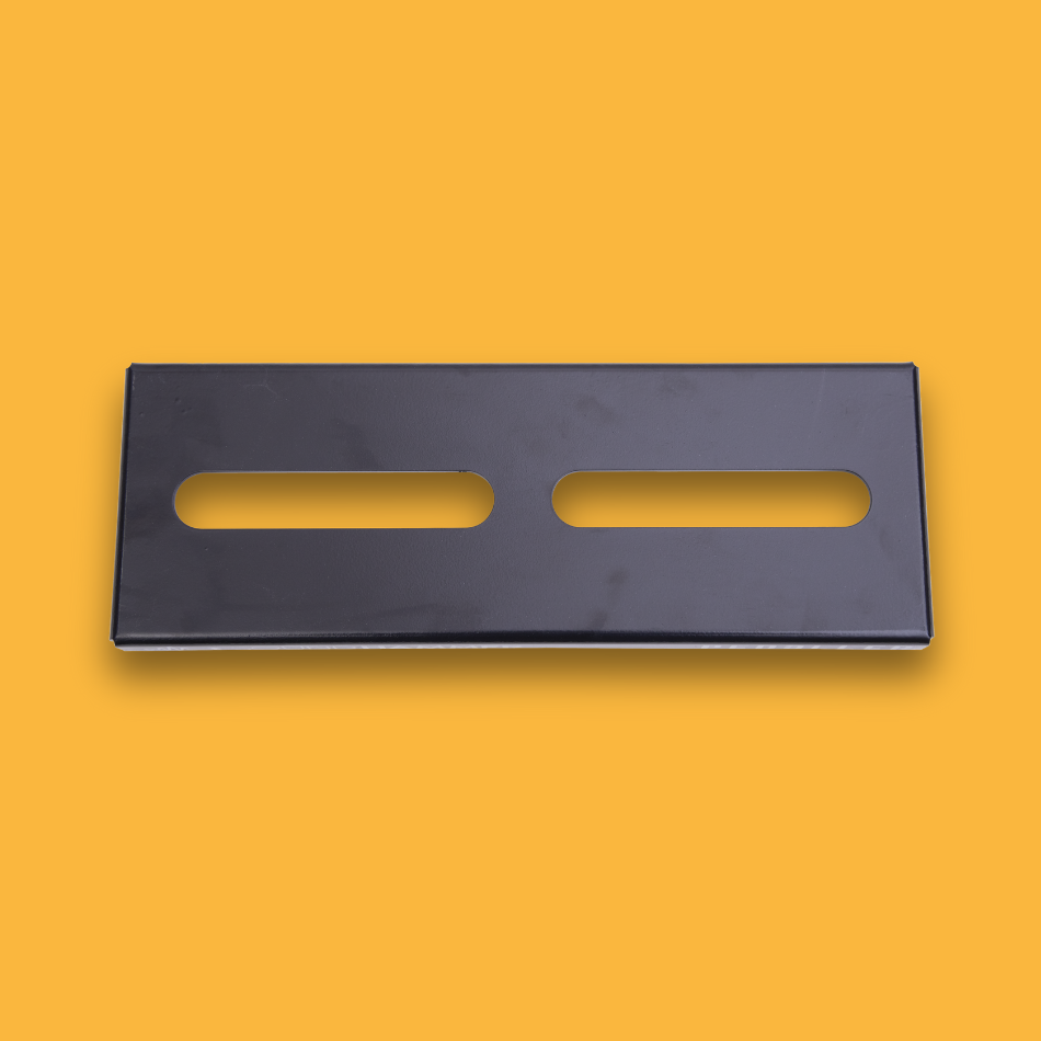 A top view of a black guitar effects pedalboard made of single sheet of aluminium with two long holes for cable management.