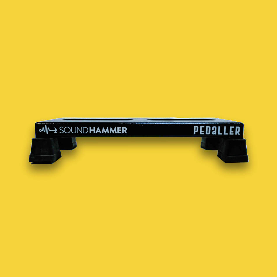 A side view of a lifted black guitar effects pedalboard made of single sheet of aluminium with 4 legs and rubber bushings with Soundhammer logo.