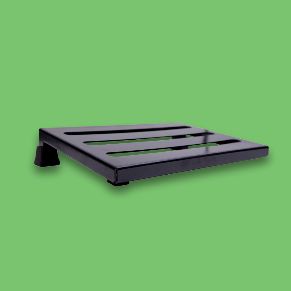 An angled view of an incline black guitar effects pedalboard made of single sheet of aluminium with 2 legs and rubber bushings.