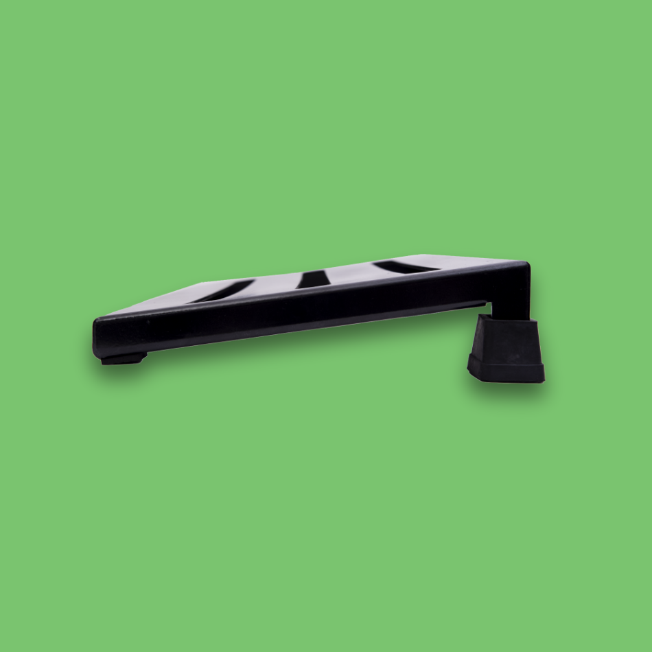 A side view of an incline black guitar effects pedalboard made of single sheet of aluminium with 2 legs and rubber bushings.