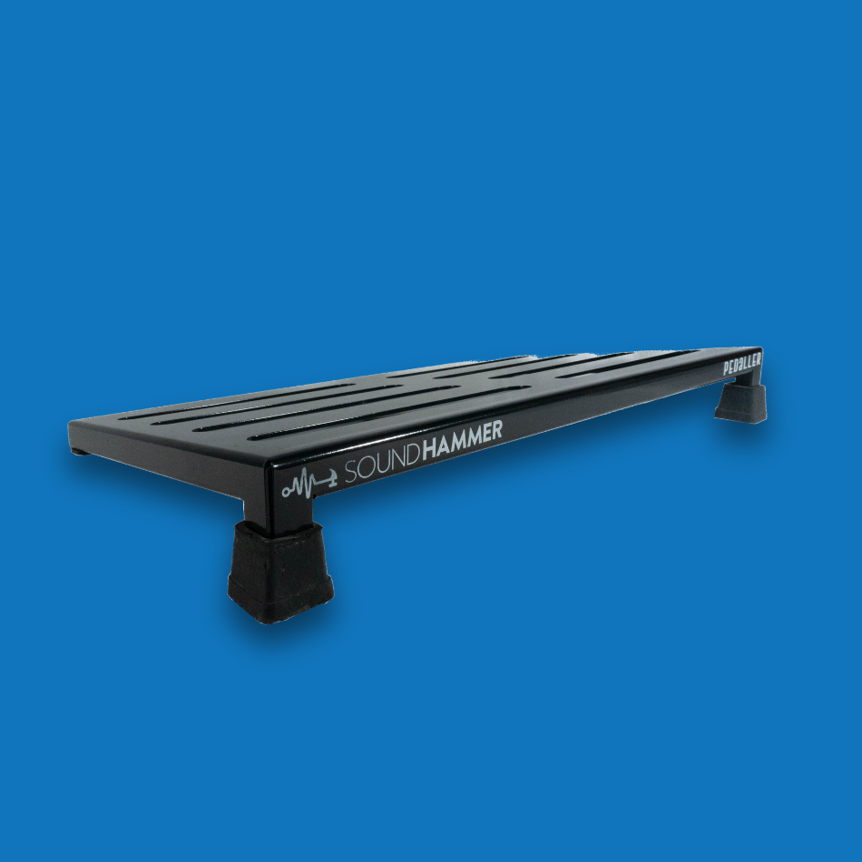 A top angled view of a large incline black guitar effects pedalboard made of single sheet of aluminium with 2 legs and rubber bushings with Soundhammer logo.