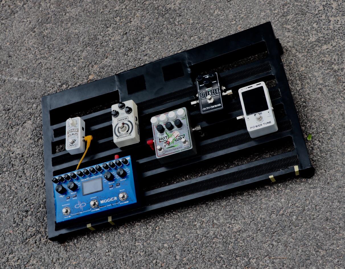top view of custom made black guitar pedalboard with couple of guitar effect pedals on top