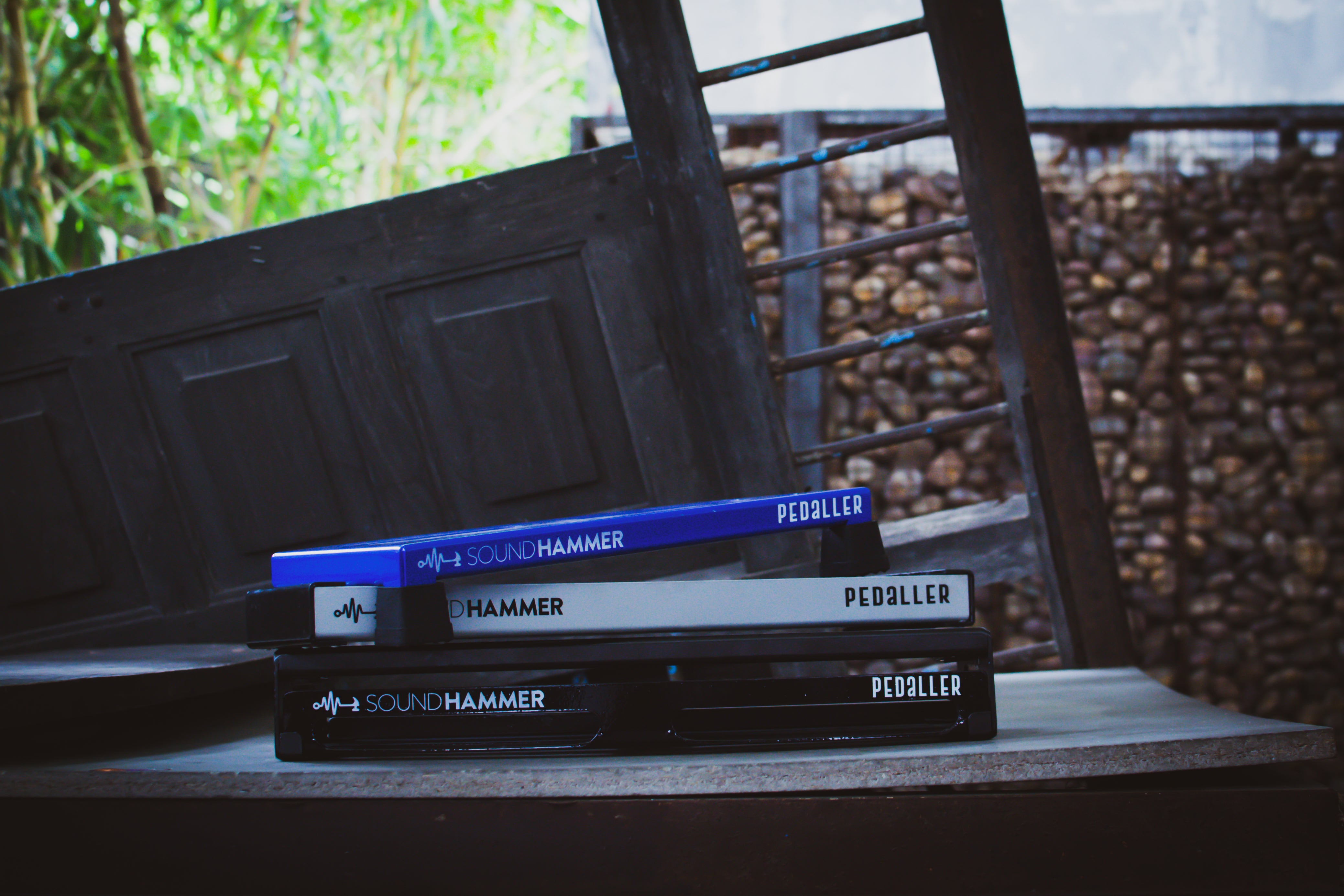 front view of multicolor guitar pedalboards kept stacked on top of each other