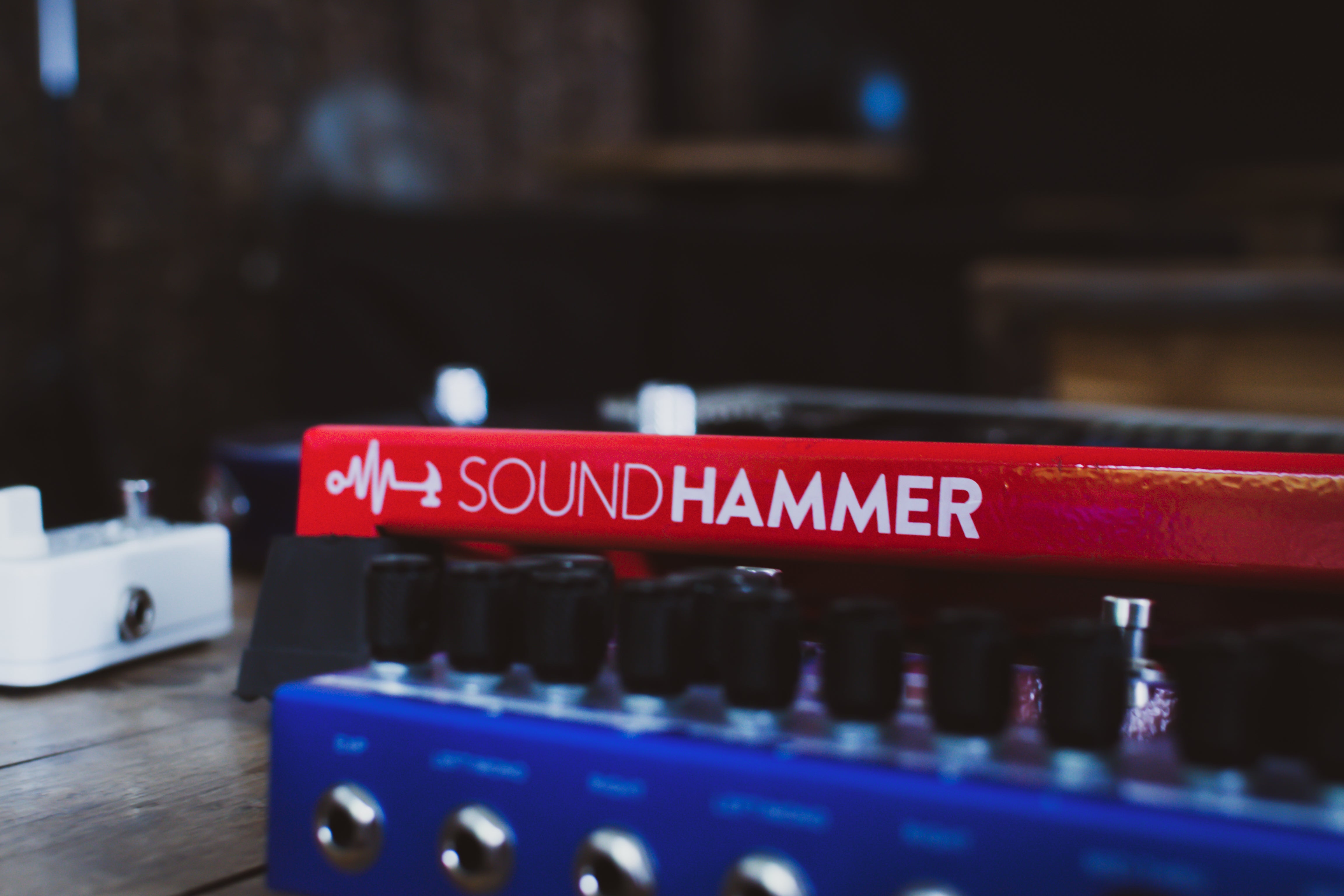 extreme close up of a red custom pedalboard made by soundhammer