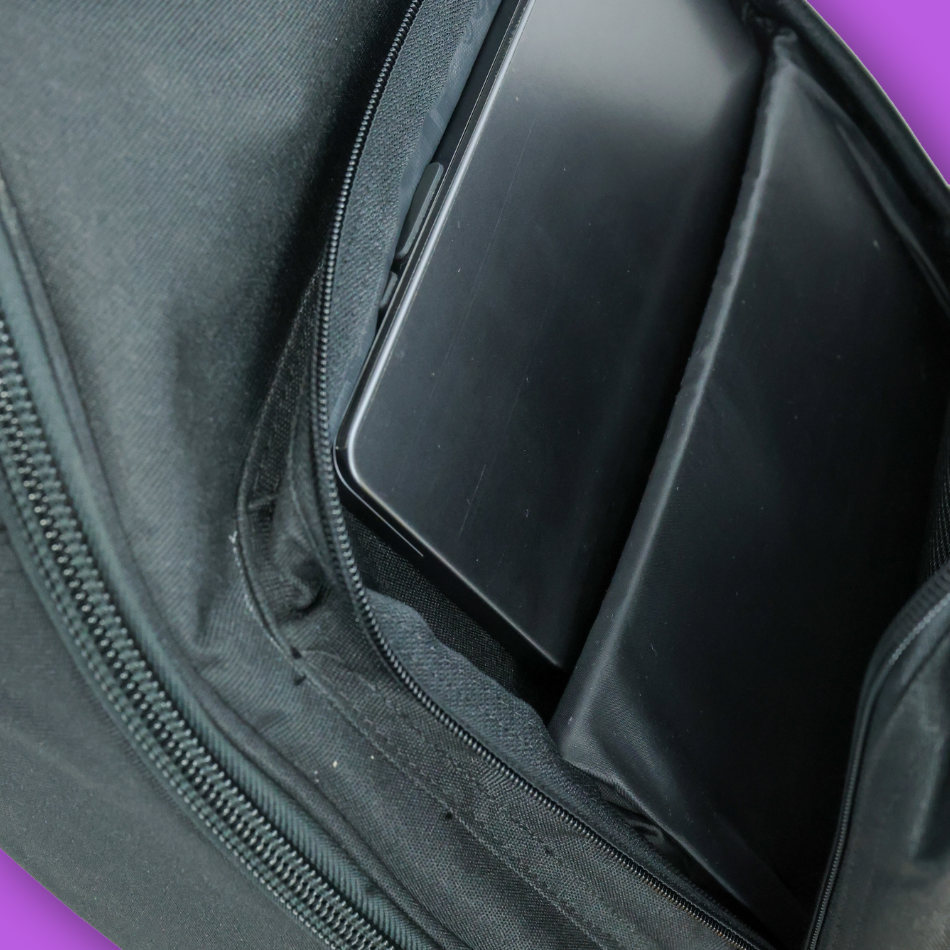 Close up view of front pouch of bass guitar case with open views and a laptop inside.