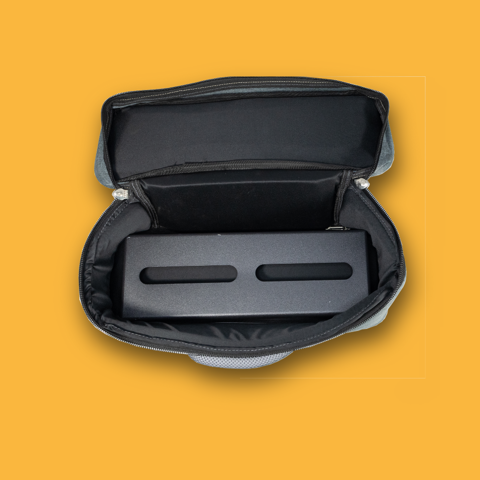 Black pedalboard gig bag with open lid on a orange background