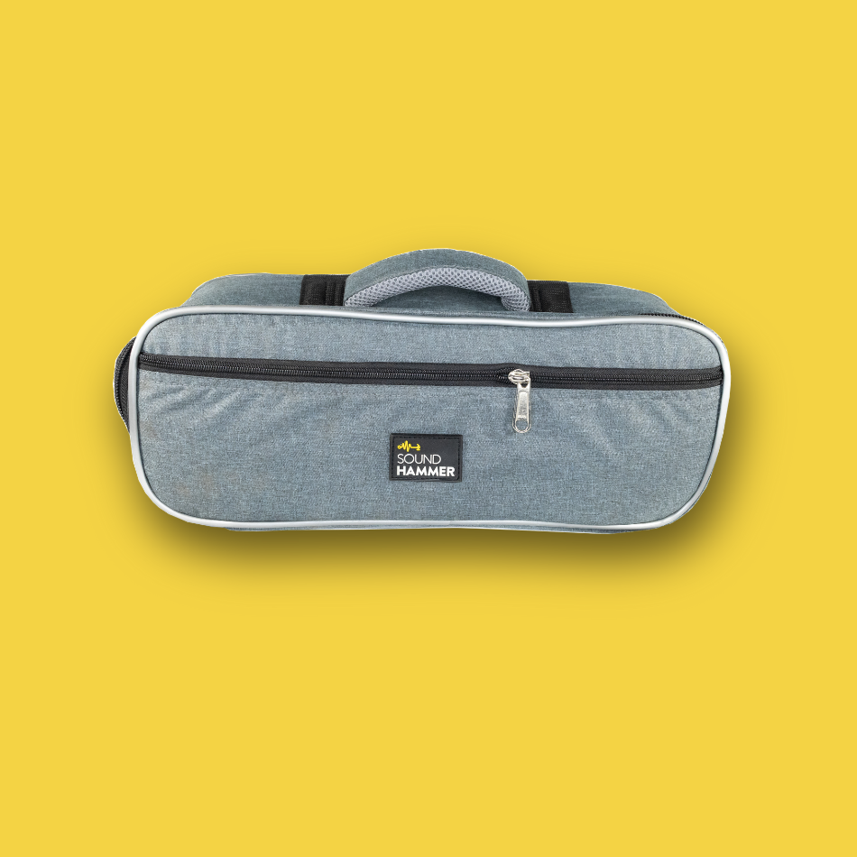 Gray pedalboard gig bag with black accents on a yellow background front view