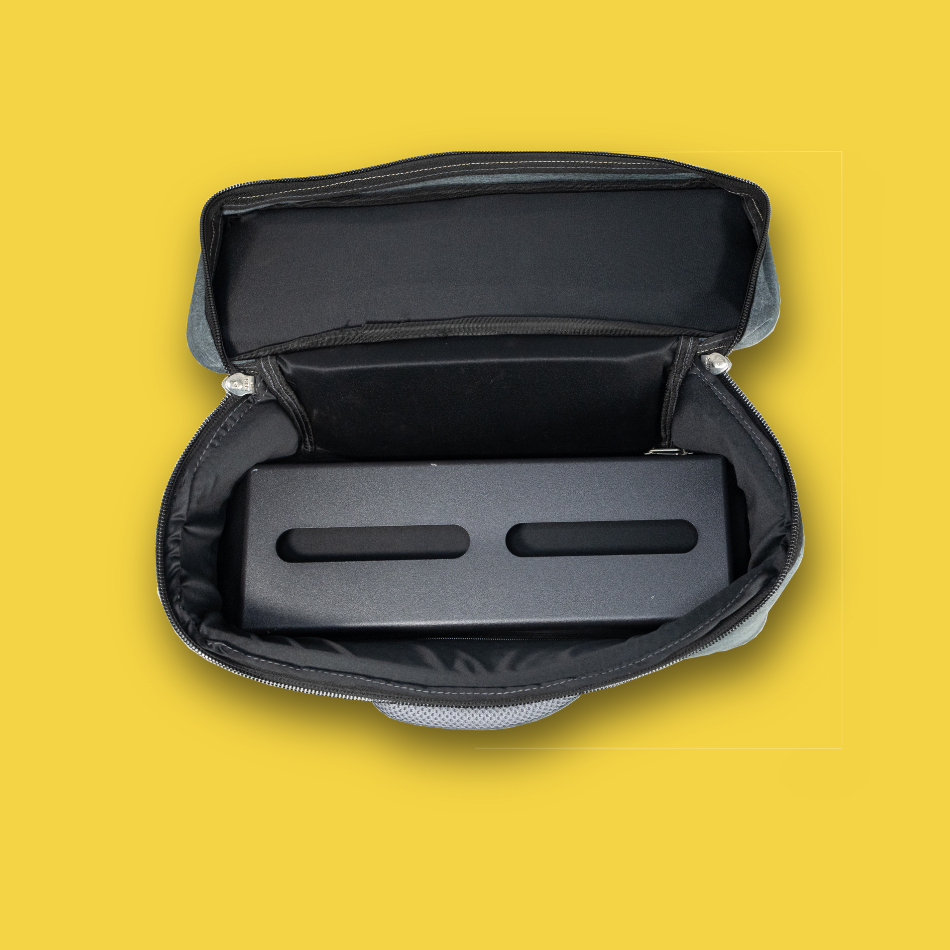 Black pedalboard gig bag with open lid on a yellow background