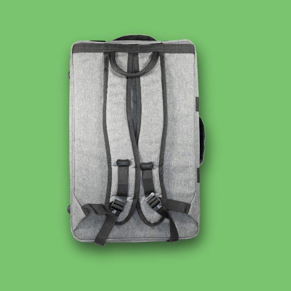 Gray pedalboard gig bag with black straps on a green background