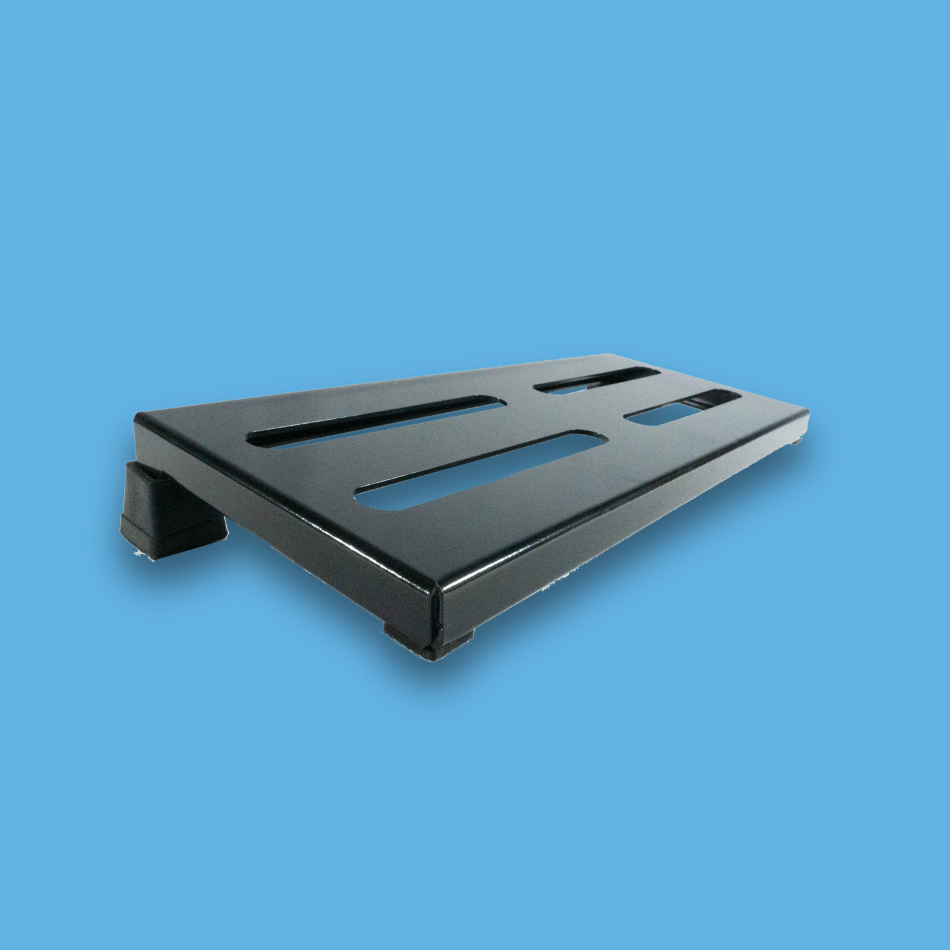 An angled view of a long incline black guitar effects pedalboard made of single sheet of aluminium with 2 legs and rubber bushings.