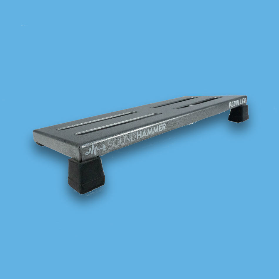 A top angled view of a long incline grey guitar effects pedalboard made of single sheet of aluminium with 2 legs and rubber bushings with Soundhammer logo.