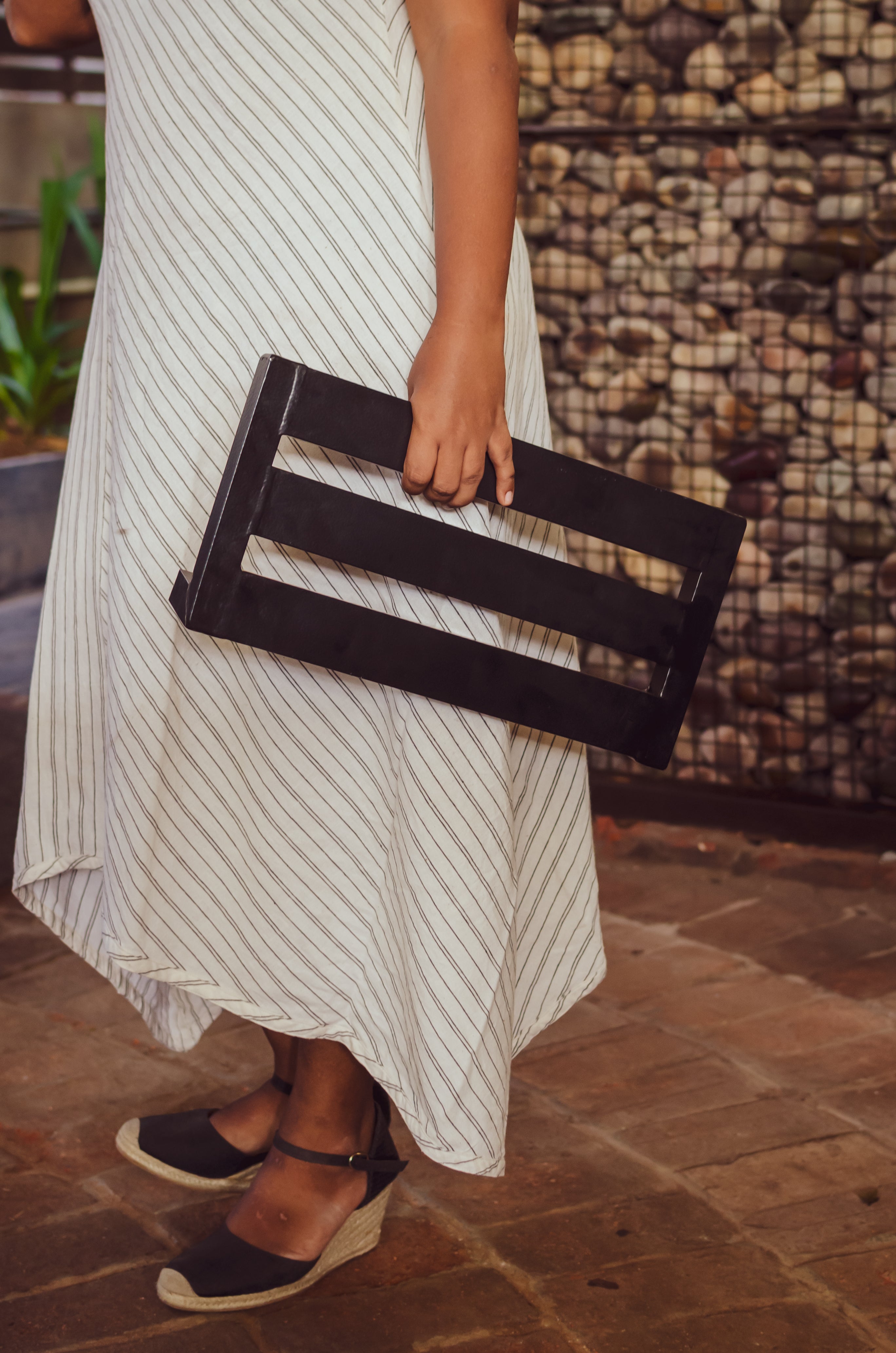 Shilpa standing with a black guitar pedalboard